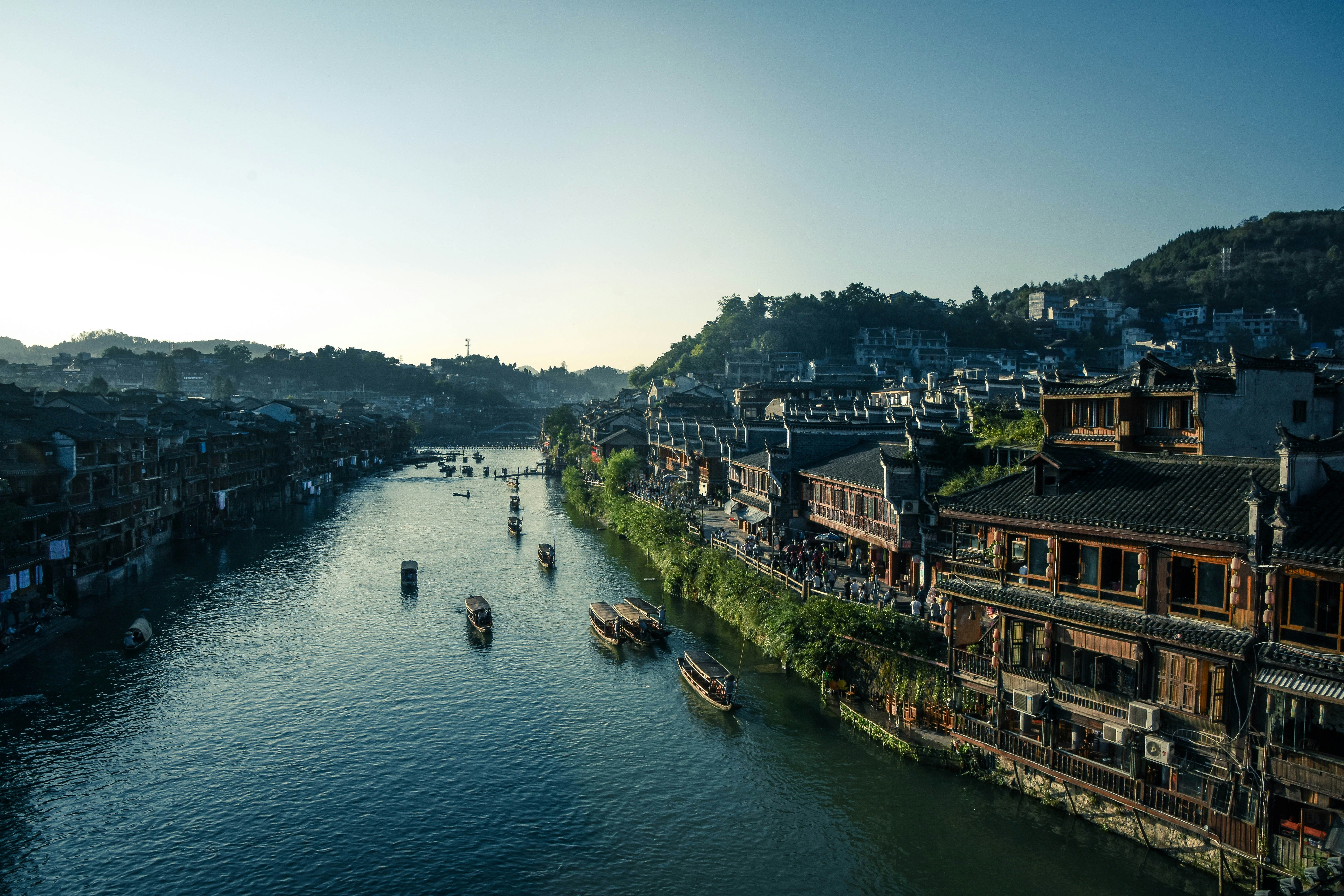 A serene traditional Chinese water town at sunset, with ancient buildings reflecting in calm waters, symbolizing the flow and harmony of the Five Elements